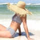 day at the beach ocean waves sunshine blue sky floppy oversized straw hat with fringed edges beach fashion boho chic hat bohemian style boho summer fashion